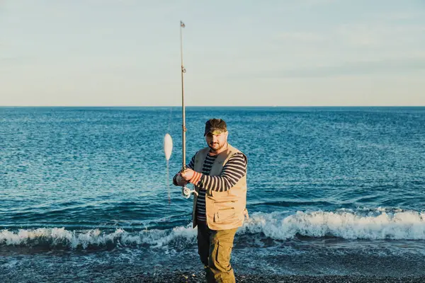 Denizde güneşli bir günde balık tutan adam 