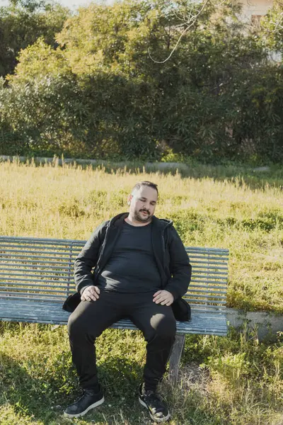 Sıkıcı adam bankta esniyor. . 