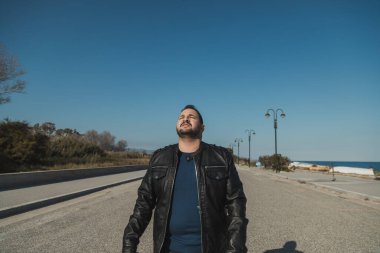 Sahilde güneşli bir gün geçiren bir adam.