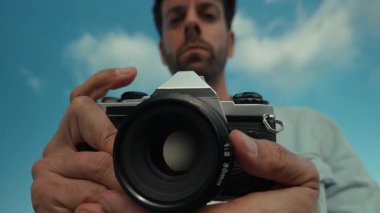 Adam kumsalda eski kamerayı tutuyor ve ayarlıyor. . 