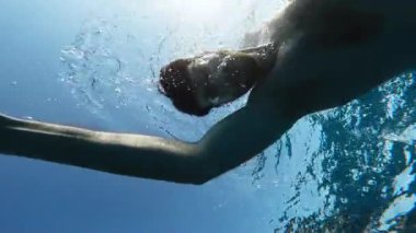 Çocuk denizde yüzüyor.