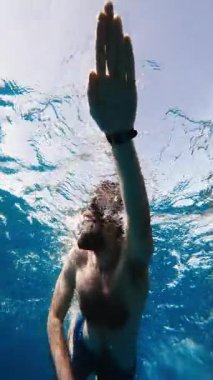 Çocuk denizde yüzüyor.