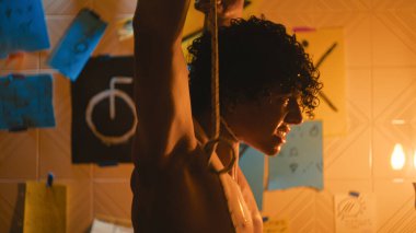 Adam yüzünü yıkıyor ve ipin intihara hazırlanmasını izliyor..