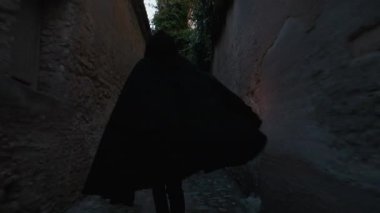 Koyu renk elbiseli bir adam ve yürüyen ve arayan bir fener. 