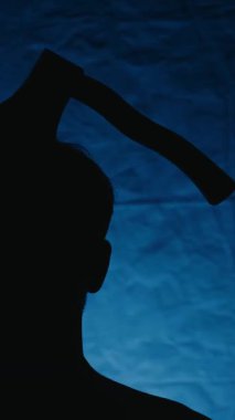 Cadılar Bayramı gecesi kafasında balta olan bir adamın silueti. Yüksek kalite 4k görüntü