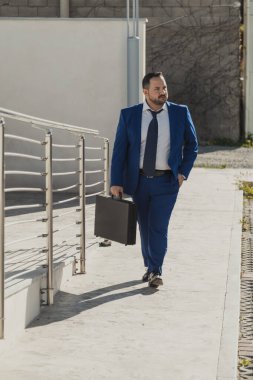 Güneşli bir günde takım elbisesiyle kendinden emin bir iş adamı..