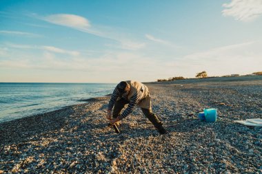 Denizde güneşli bir günde balık tutan adam 