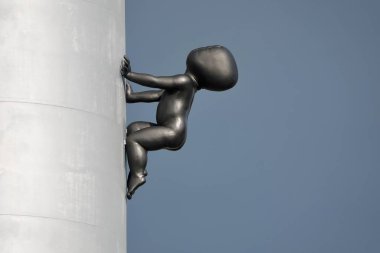 Prag, Çek Cumhuriyeti - 17 Mayıs 2022: Zizkov Televizyon Kulesi 'nde yüzsüz bronz bir bebeğin heykeli. Çek sanatçı David Cerny tarafından tasarlanan bu heykeltraşa miminka adı verilir. Yüksek kalite