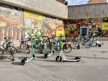 Prag, Çek Cumhuriyeti - 20 Mayıs 2023: Prag 'da Billa mağazası yakınlarındaki kaldırıma kaotik bir şekilde yayılmış birçok ortak bisiklet ve scooterlar. Yüksek kalite fotoğraf