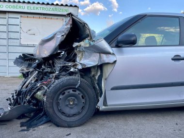 Bir araba kazasında ağır hasar görmüş gümüş bir arabanın önü. Bu durumda, araba hareket edemez ve tamir edilmesi çok zordur. Yüksek kalite fotoğraf