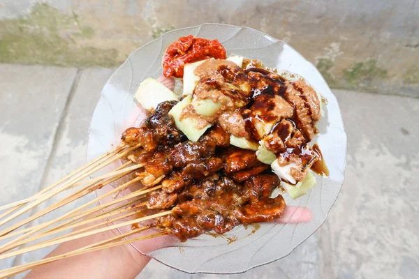 Sate Ayam madura, fıstık soslu tavuk ve pirinç keki, ünlü Endonezya tipik mutfağı.