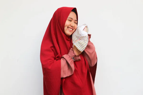 妊婦の概念は 幸せなアジアのイスラム教徒の女性を保持し 子宮の中で彼女の子供のための巨大な赤ちゃんの服 — ストック写真