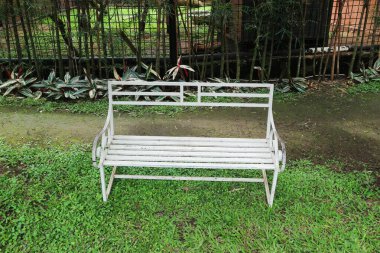 Şehir parkında beyaz demir bir bank