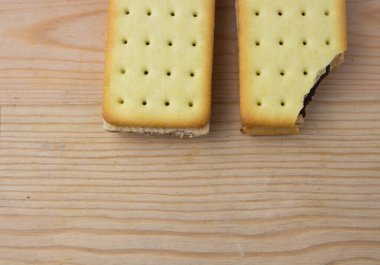 Tahta arka planda çikolata ve peynirli kraker yığını.