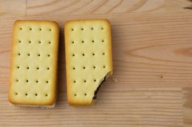 Tahta arka planda çikolata ve peynirli kraker yığını.