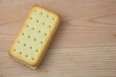 Tahta arka planda çikolata ve peynirli kraker yığını.