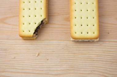 Tahta arka planda çikolata ve peynirli kraker yığını.