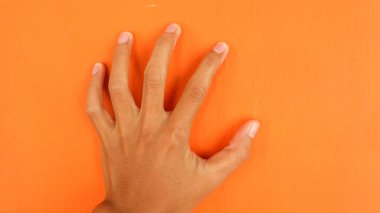 Turuncu arka planda el pençe, insan vücudu parçası konsepti
