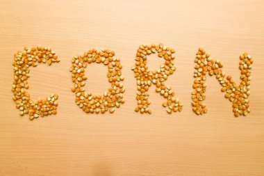 Sarı mısır tohumları kahverengi ahşap arka planda patlamış mısır için 