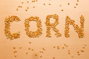 Sarı mısır tohumları kahverengi ahşap arka planda patlamış mısır için 