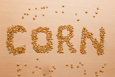 Sarı mısır tohumları kahverengi ahşap arka planda patlamış mısır için 