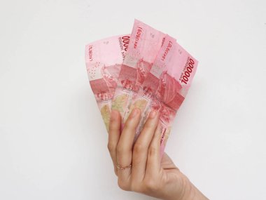 Beyaz arka planda izole edilmiş toplam üç yüz bin rupia banknotuyla el ele tutuşmak. Endonezya Rupisi