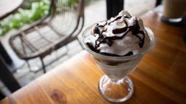 Çikolata soslu cam kasede vanilyalı dondurma.