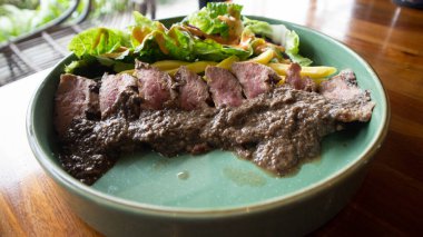 Avustralya usulü biftek ve taze salata ve mantar sosu.