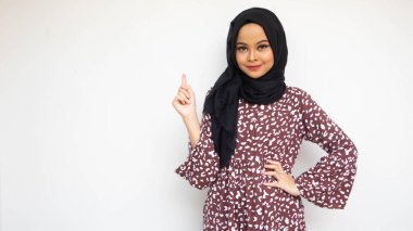 Gülümseyen Asyalı genç kadının portresi beyaz arka planda fotokopi alanını işaret ediyor