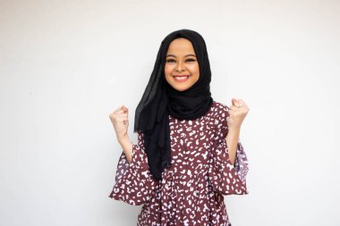 Asyalı genç kadın beyaz arka planda izole edilmiş zaferi kutluyor.