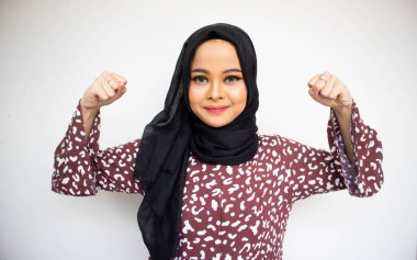 Beyaz arka planda tecrit edilmiş Asyalı genç kadın güçlü kas gücü hareketi gösteriyor. Beyaz arka plana karşı iç güç liderlik kavramı.