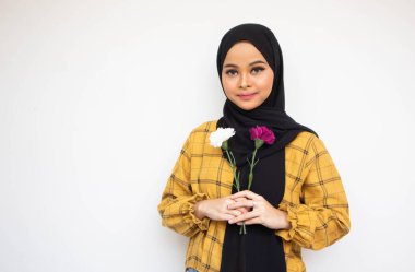 Beyaz arka planda iki çiçek sapı tutan neşeli genç Asyalı kadın.