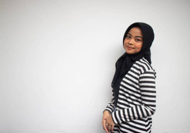 Siyah beyaz çizgili gülümseyen Asyalı Müslüman bir kadının portresi beyaz bir elbisenin içinde kendinden emin görünüyordu.