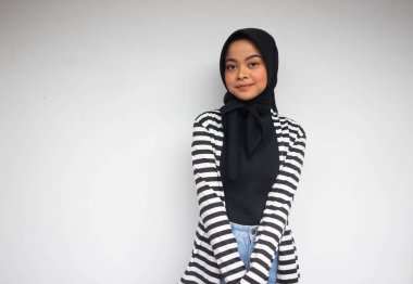 Siyah beyaz çizgili gülümseyen Asyalı Müslüman bir kadının portresi beyaz bir elbisenin içinde kendinden emin görünüyordu.