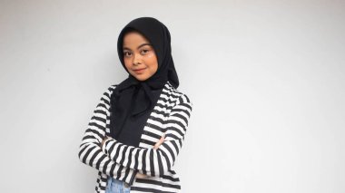 Siyah beyaz çizgili gülümseyen Asyalı Müslüman bir kadının portresi beyaz bir elbisenin içinde kendinden emin görünüyordu.