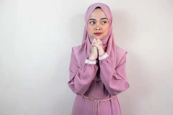 Beautiful asian hijab woman feel stressed and anxious while praying isolated on grey background