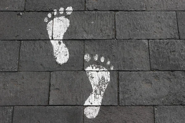 舗装ブロック上の足跡の白い塗料 — ストック写真