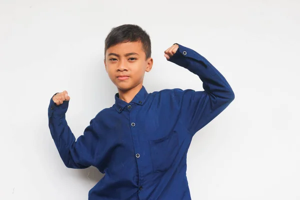 Mavi Gömlekli Asyalı Çocuk Beyaz Arka Planda Kaslarını Pazılarını Gösteriyor — Stok fotoğraf