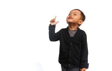 Gülümseyen bir çocuk beyaz arka planda izole bir şekilde ellerini kaldırıp yukarı bakıyor.