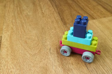 Plastik yapı taşları ahşap zeminde araç oluşturur