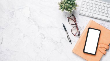 Üst görünüm, bilgisayar klavyesi, gözlüklü beyaz ofis masası, boş ekran akıllı telefon, kalem ve defter, kopyalama alanı,..