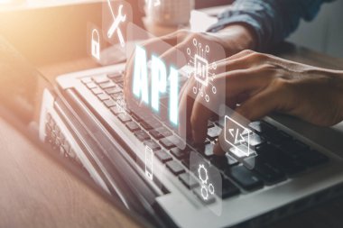 API - Uygulama Programlama Arayüzü, Ofis masasında VR ekran API simgesi olan dizüstü bilgisayar kullanan kadın, Yazılım geliştirme aracı, modern teknoloji, internet ve ağ konsepti.