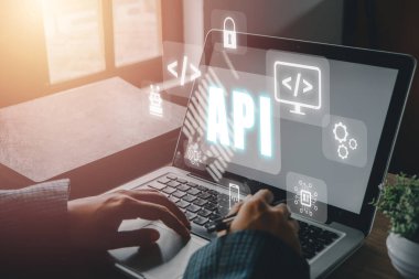 API - Uygulama Programlama Arayüzü, Ofis masasında VR ekran API simgesi olan dizüstü bilgisayar kullanan kadın, Yazılım geliştirme aracı, modern teknoloji, internet ve ağ konsepti.