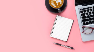 Top view, Pink Office desk with laptop computer, eyeglass, cup of coffee, pen and notebook, copy space, Mock up...	
