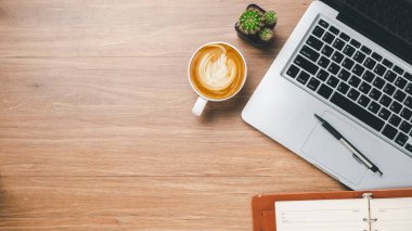 Top view, Office desk with laptop computer, cup of coffee, pen and notebook, copy space, Mock up.	