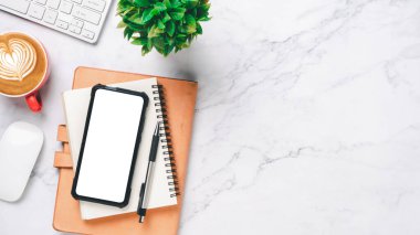 Bilgisayarlı beyaz ofis masası, boş ekran akıllı telefon, defter, kalem, kahve fincanı, fotokopi alanı olan üst görünüm,.