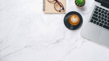 Üst Manzara, dizüstü bilgisayarlı beyaz ofis masası, bir fincan kahve, gözlük ve defter, kopyalama alanı,.