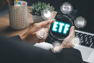 ETF Borsası hisse senedi borsası ticari yatırım finans kavramı, iş kadınları VR ekranında ETF simgeleriyle akıllı telefon kullanıyor.