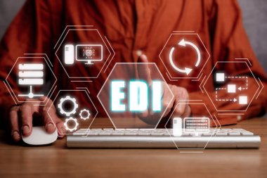 EDI-elektronik veri değişimi kavramı, ofis masasında sanal ekran EDI simgesi ile bilgisayar kullanan kişi.