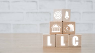 Sınırlı Sorumluluk Şirketi (LLC) İş Konsepti, ahşap blok Vr ekran üzerinde sınırlı sorumluluk şirket simgesi ile masa üzerinde.